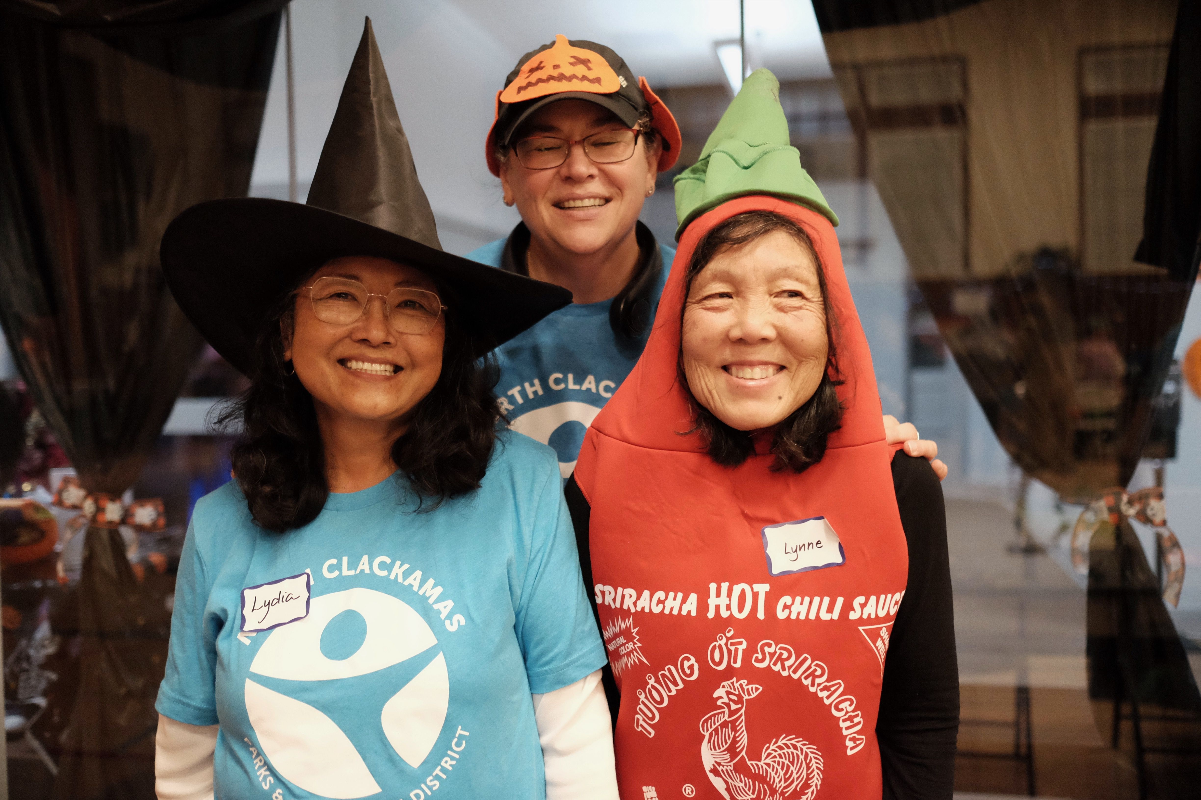 Three volunteers wearing halloween costumes