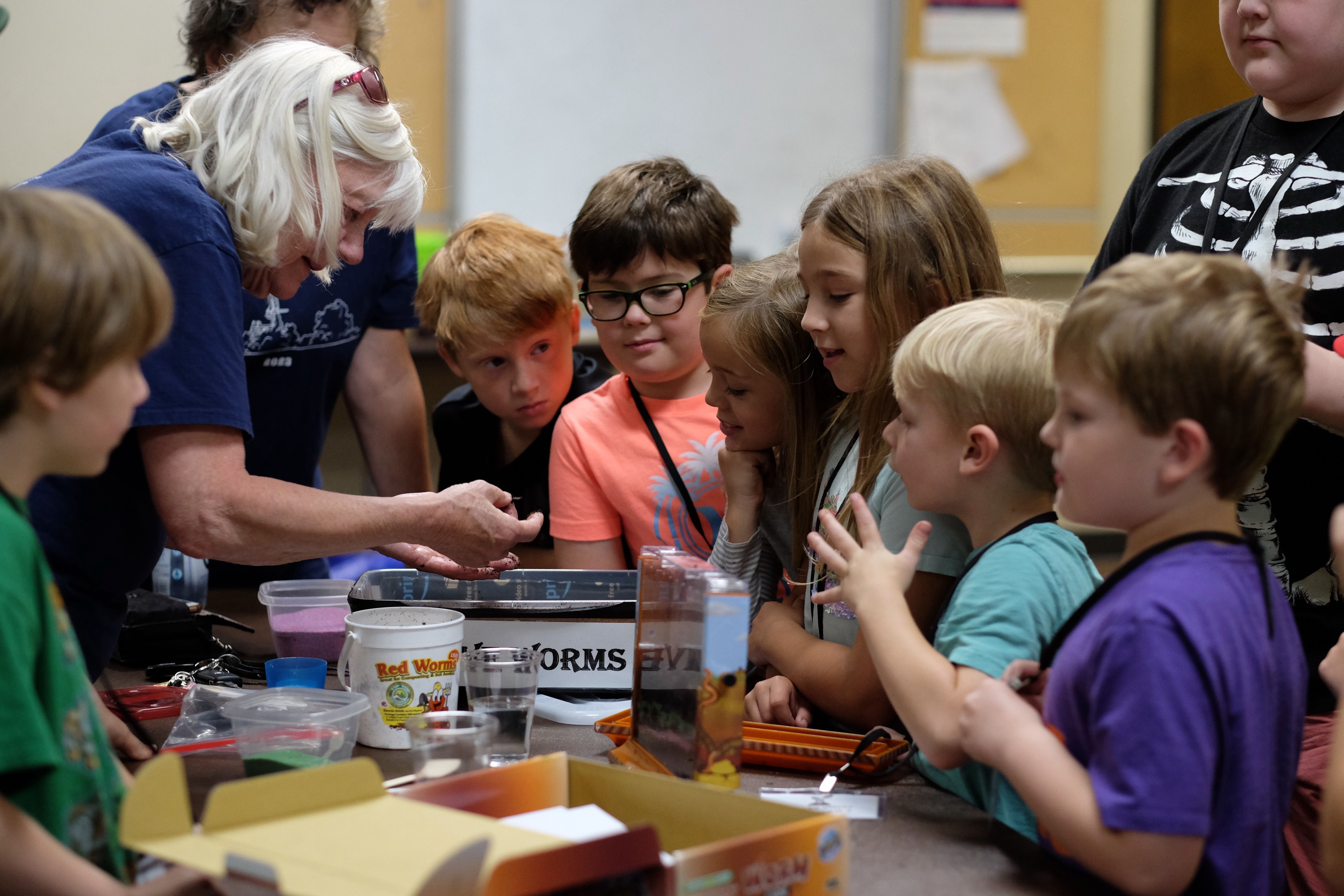 Children in science class looking at worms